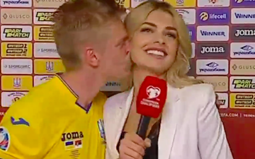 Nữ phóng viên cười e thẹn, ngại ngùng lấy bảng che mặt sau khi để cầu thủ xuất sắc nhất Ukraine hôn trên sóng truyền hình